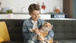 Home Alone, Little Boy Without Friends Plays With A Toy Tiger.Brown Toy Tiger In Child's Hand. Child Playing With A Toy Tiger In The Living Room.