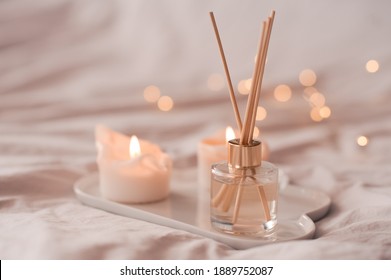Home Aroma Fragrance Diffuser With Burning Candles On White Tray In Bed Over Glowing Lights Close Up. Cozy Atmosphere. Wellness. Healthy Lifestyle. 