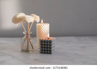 Home Aroma Fragrance Diffuser And Burning Candles On Marble Background. Interior Elements. Home Aroma. Wellness