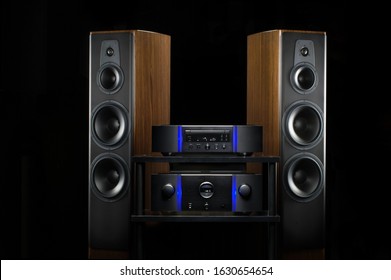 Home audio loudspeakers isolated on black background. Warm loud sound. Luxury stereo system for print and web design. Soft glowing edges. Wooden finish of the case.