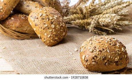 Home baked bread. Rye bakery with crusty loaves and crumbs. Fresh rustic traditional bread with wheat grain ear or spike plant on natural cotton background. Design element for bakery product label
