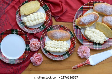 Home Baked Sweet Bread Rolls  With Fresh Cheese And Cream On Wooden Table. Sweet Sandwich Breads On Red Plates With Red Tablecloth And Roses. Sliced Small Breads, Milk Buns Stuffed With Creamy Cheese.