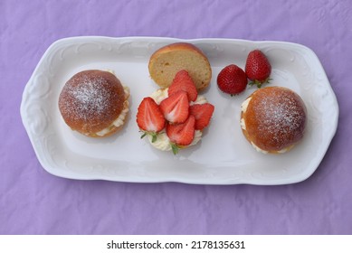 Home Baked Sweet Bread Rolls With Fresh Cheese And Strawberries. Sweet Sandwich Breads With Fruits On Violet Tablecloth. White Plate With Sliced Small Breads, Milk Buns Stuffed With Creamy Cheese.