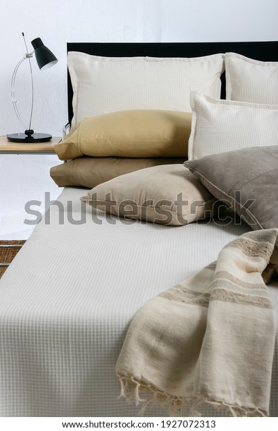 Home and bed products such as pillows,\
bedsheets, bedspreads, comforters, quilts and blankets,all in beige\
tones, in exhibition.