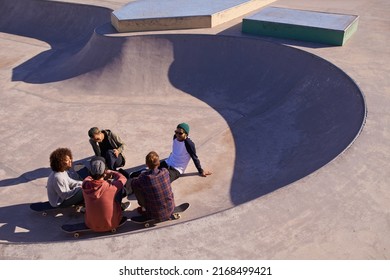 At Home In The Bowl. Shot Of A Group Of Friends Hanging Out In The Sun At A Skate Park.