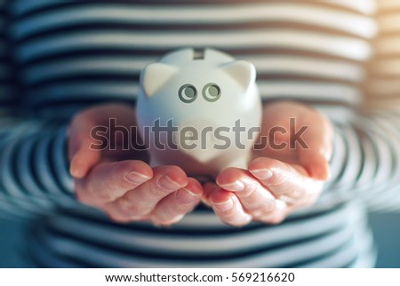 Home budget concept with piggy coin bank in female hands