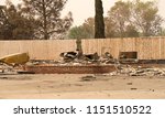 home burned to the ground, fence left untouched in the recent wild fire fire storm in Redding, California. Smoke and ash in the air as the fire continues to burn several miles away.