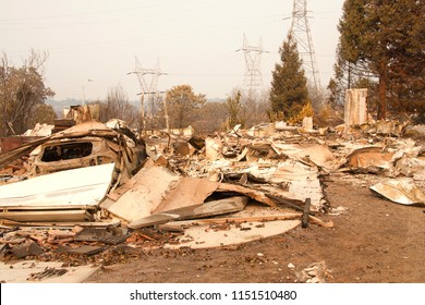 Home Burned To The Ground, Garage Door Buckled And Laying In A Heap After The Recent Wild Fire Fire Storm In Redding, CA. Smoke And Ash In The Air As The Fire Continues To Burn Several Miles Away.