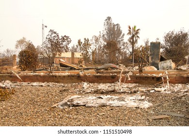 Home Burned To The Ground In The Recent Wild Fire Fire Storm In Redding, California. Building In Background Untouched. Smoke And Ash In The Air As The Fire Continues To Burn Several Miles Away.