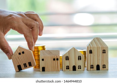 Home In Business Real Estate Investment Or Loan Concept : Hands Choose Wooden Home On Dropshipping Money Coins Placing On Table Office. Saving Moneys For Loan Mortgage Or Buy New Residential In Life