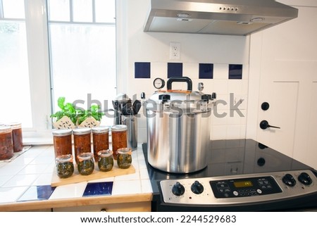 Home Canning jalapenos in jars and a batch of chili with a pressure cooker. Food preservation is key to gardening and homesteading. Pressure canning makes food shelf stable. 