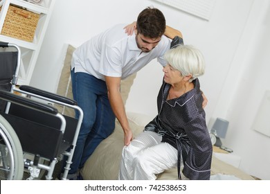 Home Caregiver Helping Senior Woman Getting Up