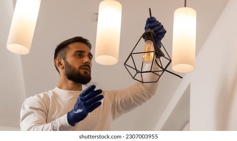 Home Ceiling Light Equipment Maintenance. Professional Electrician Worker. - Shutterstock ID 2307003955
