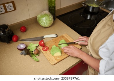 Home chef slicing avocado in a cozy kitchen setting - Powered by Shutterstock