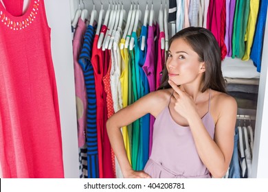 Home Closet Or Store Clothing Rack Changing Room. Woman Choosing Her Fashion Outfit. Shopping Girl Thinking What To Wear In Front Of Many Choices Of Dresses And Clothes In Organized Clean Walk-in.