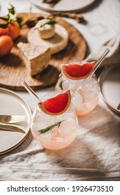 Home Cocktail Party Table Setting. Grapefruit Rosemary Margaritas In Glass, Cheese Fruit Board, Dinnerware, Cutlery On Tablecloth. Romantic Table Setting For Celebration, Stay At Home During Lockdown