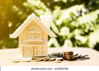 home and coin pile ahead or accumulation of money to buy housing concept.