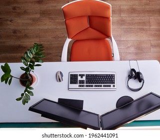 Home Computer Workstation Top View. A Wheeled Chair, A Large White Desk, And Two Monitors