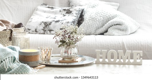 Home decorations in the interior of a letter with an inscription home on a wooden background in the interior of the bedroom with turquoise blanket