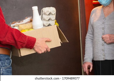 Home Delivering Food To Senior Citizens In Quarantine During Covid-19 Coronavirus Epidemic. Donation Box With Foods, Meals. Quarantine Concept. Courier Delivering Shopping To Senior Woman