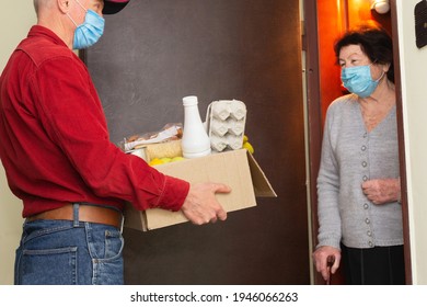 Home Delivering Food To Senior Citizens In Quarantine During Covid-19 Coronavirus Epidemic. Donation Box With Foods, Meals. Quarantine Concept. Courier Delivering Shopping To Senior Woman