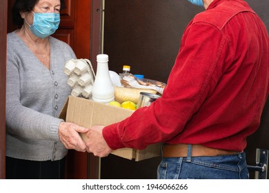 Home Delivering Food To Senior Citizens In Quarantine During Covid-19 Coronavirus Epidemic. Donation Box With Foods, Meals. Courier Delivering Shopping To Senior Woman