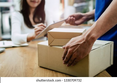 home delivery service man in blue uniform and young woman customer appending signature in digital mobile phone receiving parcel post box from courier at home, express delivery, online shopping concept - Shutterstock ID 1330709732