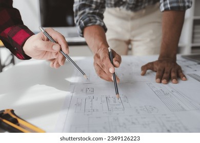 The home design architects are reviewing the house plan draft, the project commissioned by the client, and the custom design before delivery. Interior design and decoration ideas. - Powered by Shutterstock