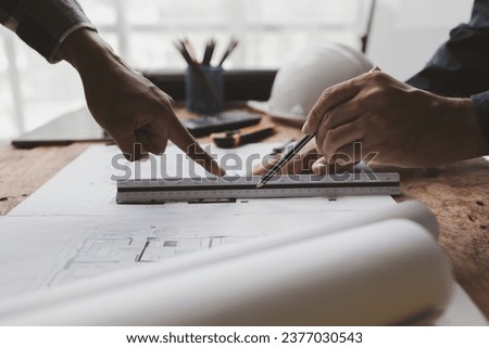The home design architects are reviewing the house plan draft, the project commissioned by the client, and the custom design before delivery. Interior design and decoration ideas.