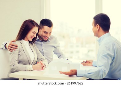 Home, Design And Architecture Concept - Couple Looking At Blueprint And Model Of Their New House At Office