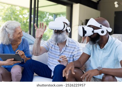 At home, Diverse group of senior friends using VR headsets and tablet, enjoying technology. seniors, virtual reality, bonding, entertainment, unaltered - Powered by Shutterstock