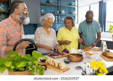 At home, Diverse group of senior friends preparing meal together in modern kitchen. Cooking, seniors, friendship, lifestyle, togetherness, unaltered - Powered by Shutterstock