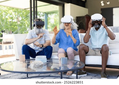 At home, Diverse group of seniors using VR headsets, enjoying virtual reality experience. Technology, entertainment, elderly, innovation, unaltered - Powered by Shutterstock