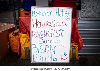 Home Drawn Sign On White Board At Food Booth At Outdoor Market In Anchorage Alaska - Reindeer Hot Dogs And Bison Burritos