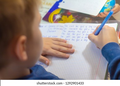 Home Education And Work After School. Boy Hand With Pen Writing English Test By Hand On Traditional White Notepad Paper 