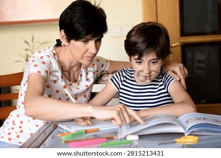 Home educator coaching young learner with textbook and notes, steady encouragement and handson demonstration, concentrated reading and problem practice, quiet