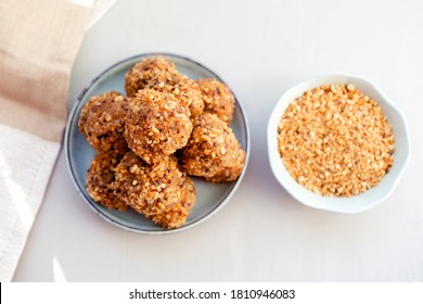 Home Energy Protein Balls With Dates, Peanut Butter, Almond And Nut Crumbs On White Table. No Cook Energy Bites, Selective Focus