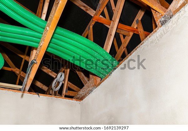 Home\
energy recovery ventilation, visible system of green flexible pipes\
for air transport, spread over the roof\
trusses.