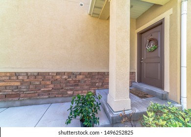 Home Entrance With Doorstep Small Porch And Brown Wooden Front Door With Wreath