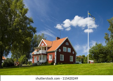 Home. Farm House In Sweden. Swedish Flag On A Flagpole. Home Sweet Home.