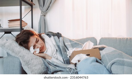Home fever. Sick woman. Unhealthy girl wrapped plaid laying sofa with napkin influenza symptoms suffering high temperature runny nose frowning face room interior. - Shutterstock ID 2316044763