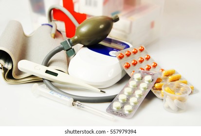 Home First Aid Kit With Different Medical Devices And Pills On Light Background