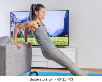 Home Fitness Woman Strength Training Arms Watching Online Tv Dvd Workouts Doing Bodyweight Exercises In Living Room Using Sofa To Do Triceps Exercise. Exercising Asian Girl In Her Apartment Indoors.