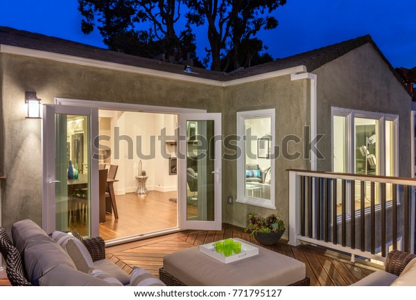 Home with
furniture patio / wooden deck at
twilight.
