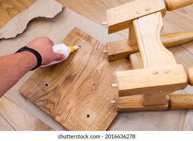 Home furniture repair. Hand applying glue to a broken oak stool. - Shutterstock ID 2016636278