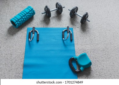 Home Gym Concept, Room With Dumbbells Kettlebell Foam Roller And Push-up Handles On Yoga Mat To Workout From Home