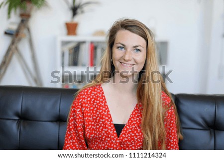 Similar – Entrepreneur woman wearing red shirt working with a laptop sitting on a couch at home