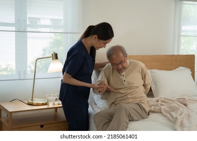 Home health care nurse caregiver take care senior elderly man at home she help support retirement oldman walking stick to bed
						