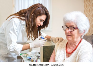 Home Healthcare Nurse Giving Injection To Elderly Woman.