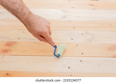 Home Improvement - A Carpenter Varnishes A Wooden Homemade Table, Holds A Plastic Roller With A Foam Nozzle In His Hand.